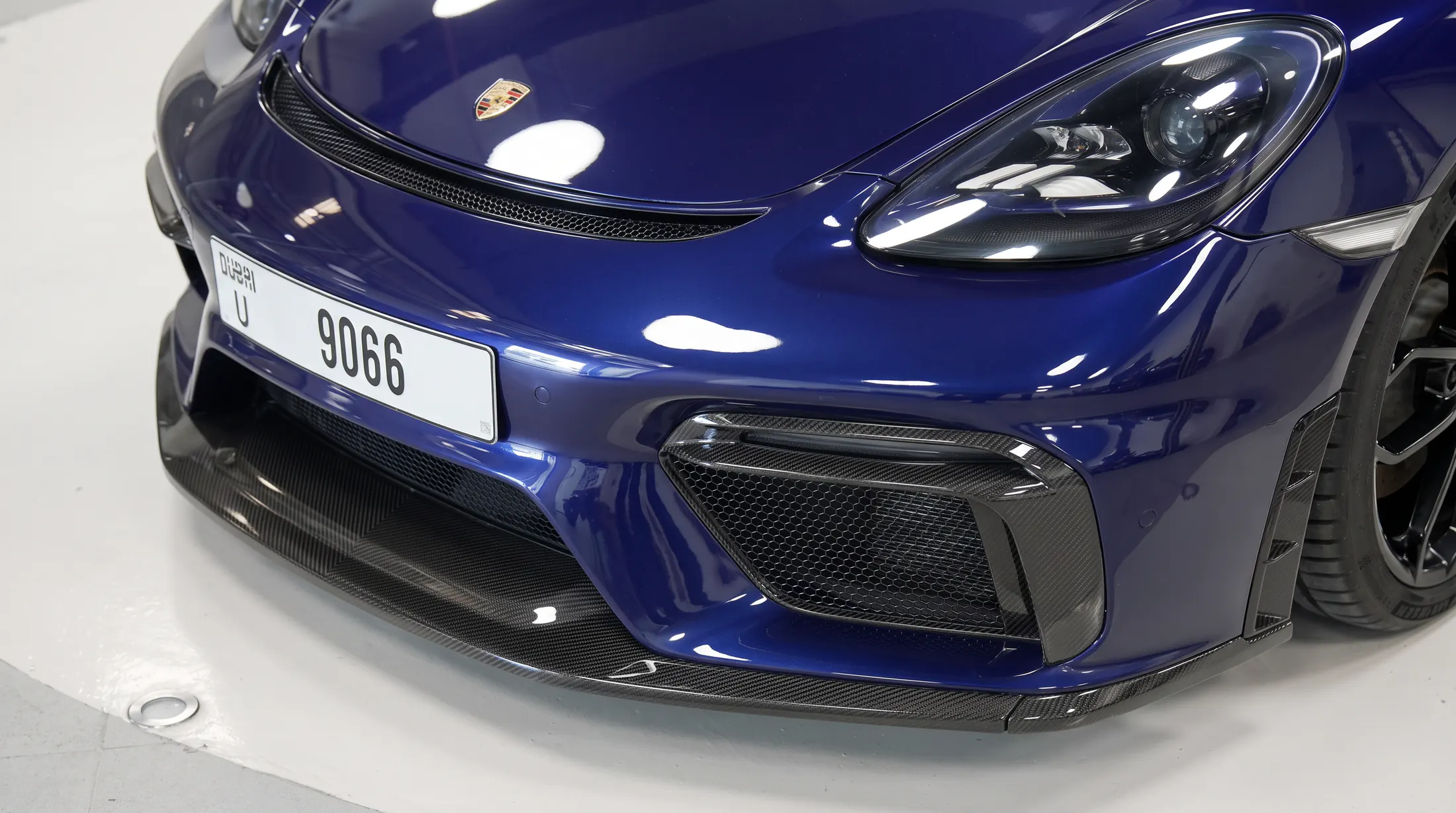 Carbon front splitter and intakes fitted to a blue Porsche